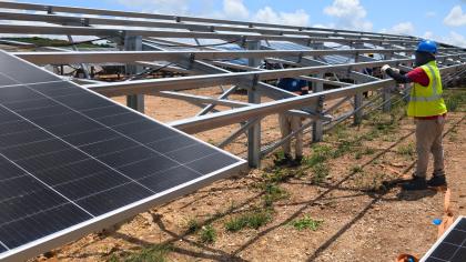 Installation of photovoltaic modules on a utility-scale solar farm.